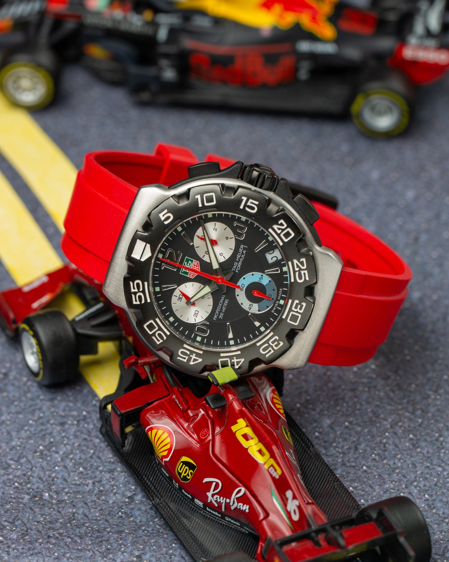 Tag Heuer Formula 1 black dial on red rubber strap on little racing car